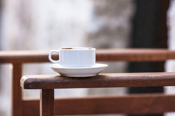 Cup of coffee on the arm of the chair