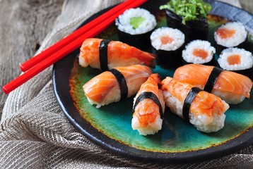 homemade sushi with wild salmon, shrimp, cucumber and seaweed. selective focus