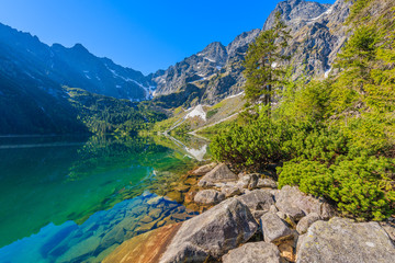 Rocks in beautiful green water Morskie Oko lake, Tatra Mountains, Poland - obrazy, fototapety, plakaty