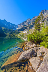 Fototapeta na wymiar Rocks in beautiful green water Morskie Oko lake, Tatra Mountains, Poland