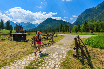 Young woman backpacker walking on hiking trail in High Tatra Mountains in summer, Slovakia