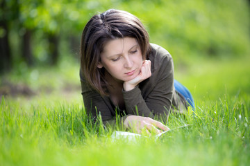 Woman reading a book in the orchard