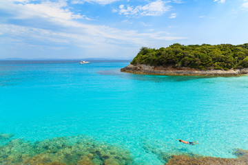 Fototapeta na wymiar Man snorkeling in turquoise sea water of Petit Sperone bay, Corsica island, France