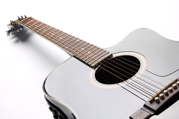 Black acoustic guitar on white background