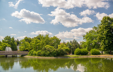 Fototapeta na wymiar Summer city park with small pond