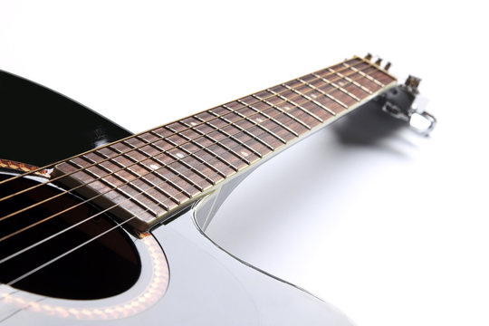Black acoustic guitar on white background