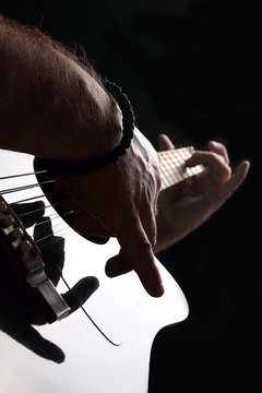Acoustic guitar close-up with fingers playing it