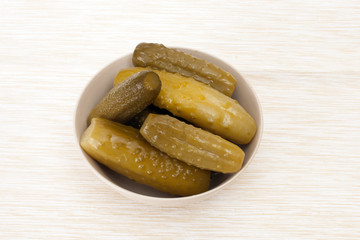 pickles in a bowl on beige tablecloths