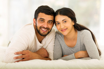 Fototapeta premium young indian married couple lying on bed