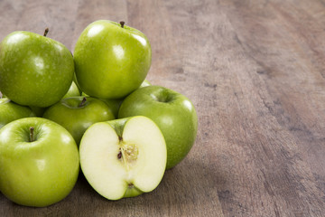 Some green apples on a wooden table