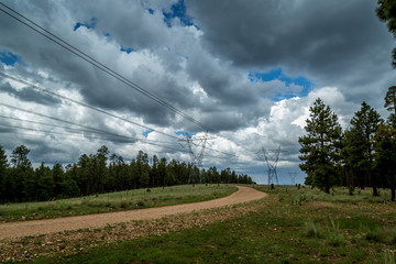 Power line road with storm clouds.