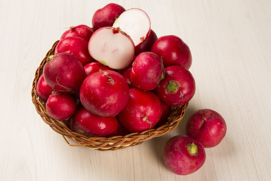 Some radishes in a basket over a white background
