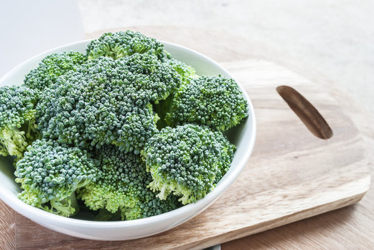 Fresh broccoli vegetable in bowl on wooden table