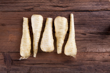 Parsnip bunch aligned shot on a wooden background from above
