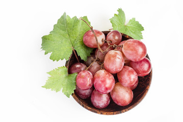 Red grape in wooden bowl, closeup, isolated on white background