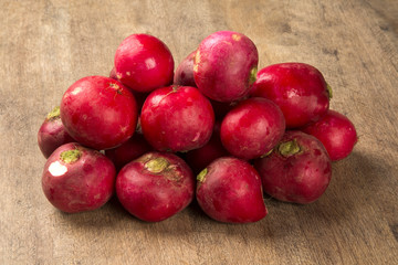 Some radishes in a basket over a wooden surface