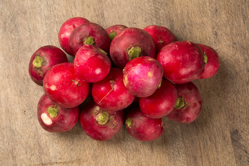 Some radishes in a basket over a wooden surface