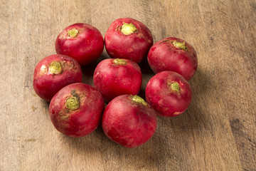 Some radishes in a basket over a wooden surface