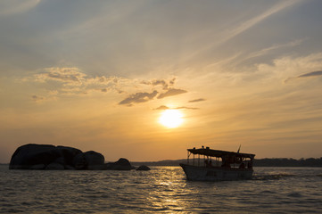 Fototapeta na wymiar Sunset on the Orinoco River with passenger boat. Ciudad Bolivar,