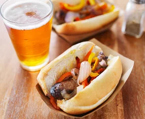 Gardinen grilled bratwurst covered in onions and peppers with beer © Joshua Resnick