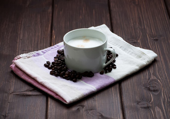 Coffee cup and grains on a wooden table
