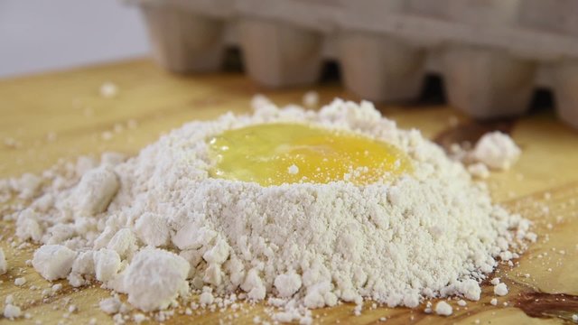 An egg dropping onto flour
