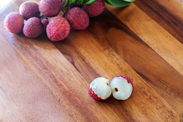 Lychee with leaves on a wooden board, still life