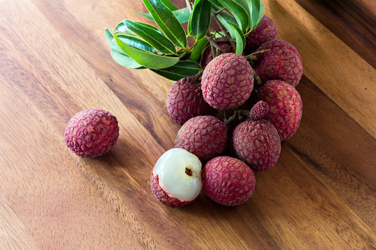 Lychee with leaves on a wooden board, still life