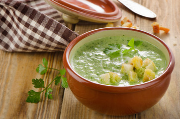 Creamy soup with  croutons on a wooden table.