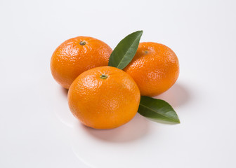 Some tangerines in a basket over a wooden surface