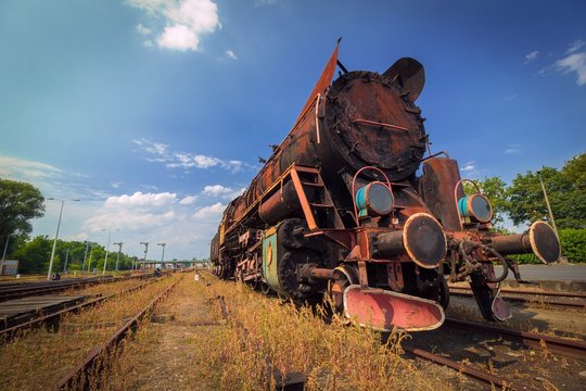 vintage old rusty steam train under blue sky