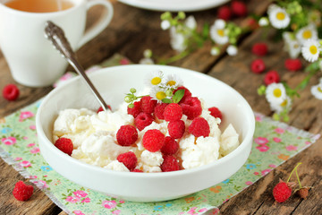 Cottage cheese with juicy fresh raspberries and beautiful chamom