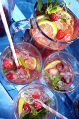 Fresh raspberry juice with mint and lemon on a blue background