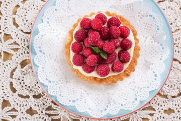 raspberry tart. Top view on raspberry dessert on crocheted tablecloth, cozy homemade sweets