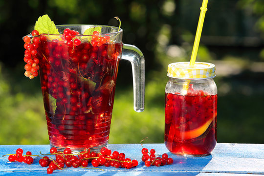 Fresh juice of red currants on a blue wooden background in the g