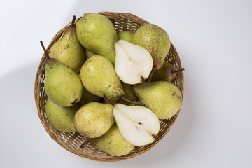Some pears in a basket over a wooden surface seen from above