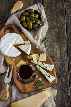 Assortment of various types of cheese on wooden board