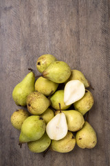 Some pears in a basket over a wooden surface seen from above