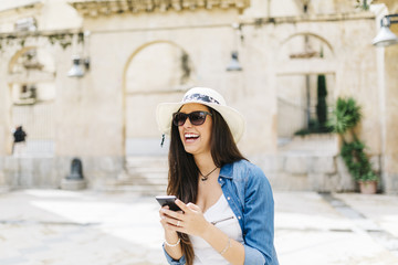 Young smiling woman text messaging on mobile phone