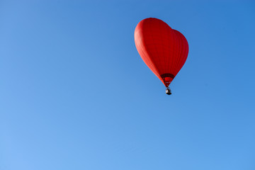 Fototapeta na wymiar red balloon in the shape of a heart against the blue sky