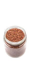 Chocolate sprinkle confetti in a mason jar over white background