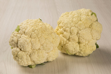 Some white cauliflowers over a wooden surface seen from above