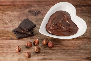 chocolate cream, hazelnut and chocolate on wooden table