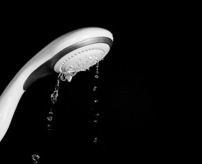 Naklejka na ściany i meble Modern shower head with running water isolated on black background