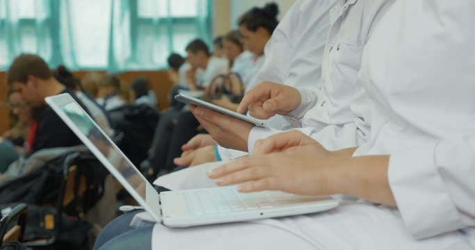 Medical students using laptop and pad on the lecture