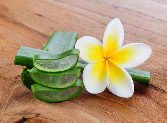 Aloe vera and frangipani flower on wooden