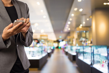 Women in shopping mall using mobile phone.