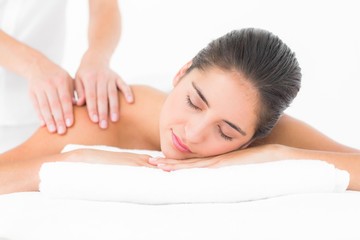 Fototapeta na wymiar Attractive woman receiving shoulder massage at spa center