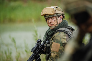 Fototapeta premium Portrait of a ranger in the battlefield with a gun