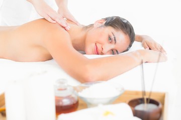 Obraz na płótnie Canvas Attractive young woman receiving facial massage at spa center